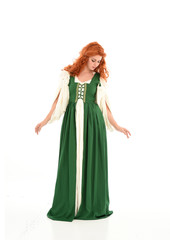 Fototapeta premium full length portrait of red haired girl wearing long green medieval gown. standing pose, isolated on white studio background.