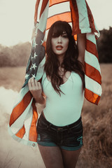 portrait of young woman holding american flag