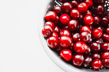 Fresh red cherries being  red sweet cherries in steel colander on white background.Healthy food concept.