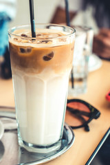 Cold iced coffee in glass. Cold summer drink. Ice latte on table.