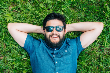 Portrait of a young happy man relaxing on the grass