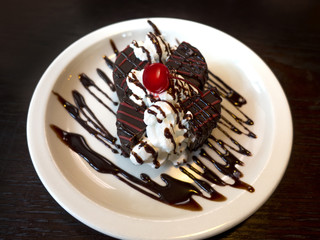 tartufo ice cream cut in four sections, maraschino cherry with cream