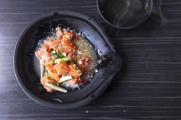 Japanese spicy salad sashimi salmon with Premium fresh raw seafood on wood background