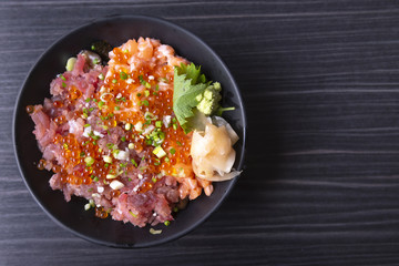 Premium fresh raw seafood mixed rice bowl (Kaisen-don/ Japanese tasty food), Japanese Rice with sashimi of tuna, Maguro, Otoro, salmon and ikura (Salmon eggs) on wood background