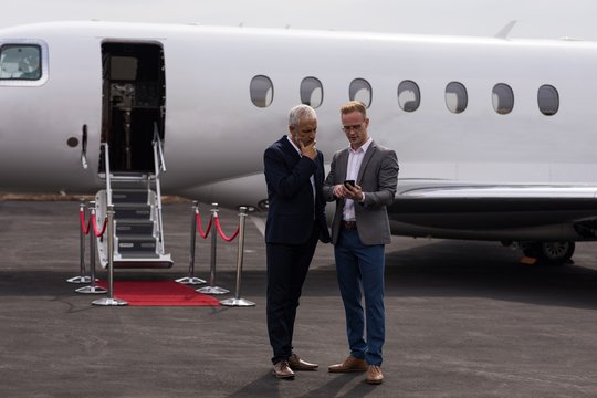 Businessmen discussing over mobile phone