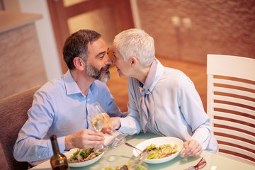 Cheerful mature couple having lunch at home
