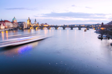 Fototapeta premium Panorama of Charles Bridge in Prague with motion blured boat, Czech Republic