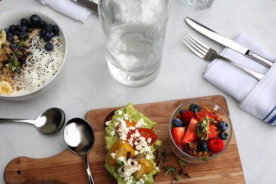 Cultured kefir and yogurt blueberries, raspberries, strawberries banana toasted silce of bread with goat cheese and guacamole
