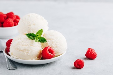 Vanilla ice cream with fresh raspberries and mint leaves