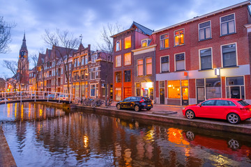 Evening view of the canal and the church in Delft. Dutch city in the spring after sunset. Holland, Netherlands.