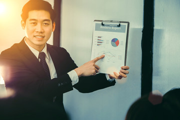Young businessman showing graph and discuss the financial information in the meeting.