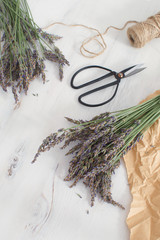 Lavender harvesting Lavender bouquet on white wooden background Aromatherapy concept Traditional medicine Top view Copy space French Provence style Toned image