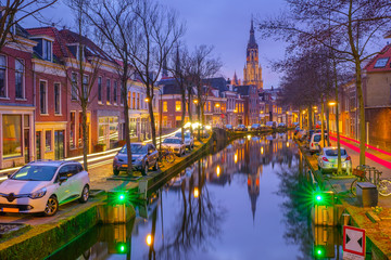 Naklejka premium Evening view of the canal and the church in Delft. Dutch city in the spring after sunset. Holland, Netherlands.