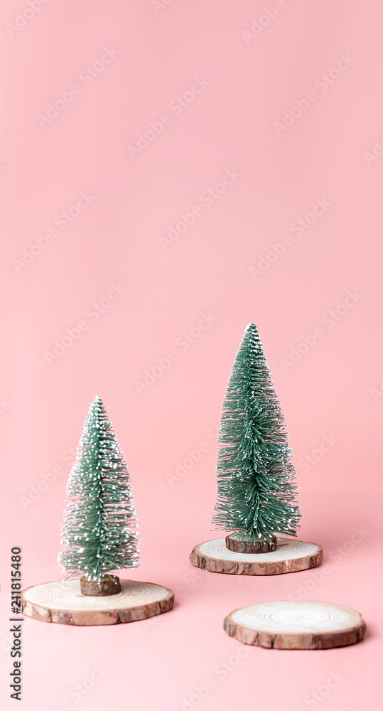 Aufkleber tree christmas tree on wood log slice on pastel pink studio background.holiday festive celebration g