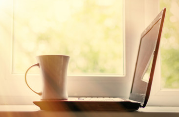 Coffee and laptop. The concept of freelancing, preparation for work, a break. Toned.