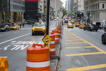 Obraz premium new york city street with. big rubber plastic barrel bolckers cars and cabs taxis