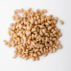 peeled pine nuts on a white acrylic background
