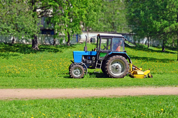Tractor with mower cutting grass