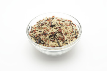 Arroz tricolor (rojo, negro y vaporizado) en un bol de cristal sobre fondo blanco