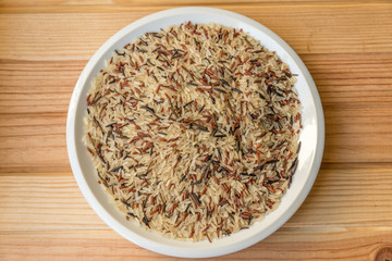 white rice and black rice on white plate on madear table