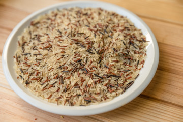 white rice and black rice on white plate on madear table