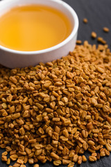 fragrant grains of fenugreek on a rustic background