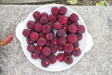 deep red fresh picked lychee fruit in a white bowl 