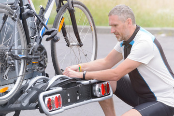 Naklejka premium Man loading bicycles on the bike rack