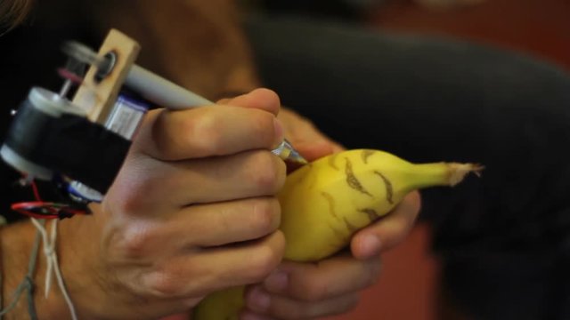 Tattooing a banana. Close up