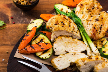 Grilled Chicken Breasts with Grilled Vegetables Zucchini and Carrot Background. Selective focus.