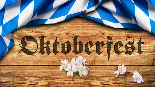 Tischtuch mit bayrischem Rautenmuster auf Holzuntergrund mit Aufschrift "Oktoberfest" 