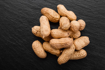 fresh peanuts on a dark stone background