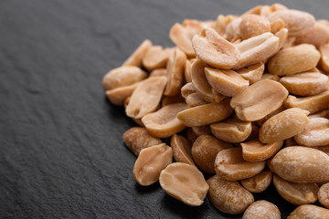 fresh peanuts on a dark stone background