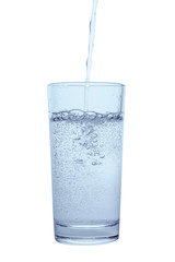 pouring mineral water in transparent glass with drops and bubbles isolated over white background, close up