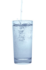pouring mineral water in transparent glass with spray and bubbles isolated over white background, close up