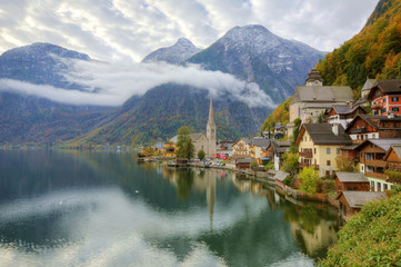 Fototapeta na wymiar Morning view of Hallstatt, a peaceful lakeside village in Salzkammergut region of Austria, with majestic mountains reflected on lake water in colorful autumn season ~ A beautiful UNESCO heritage site
