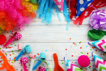Birthday party caps, blowers and balloons on wooden table