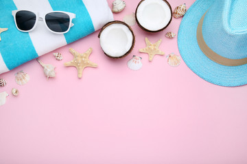 Summer accessories with coconuts and seashells on pink background