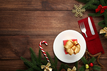 Kitchen cutlery with gift box and christmas decorations on wooden table