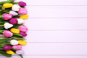 Bouquet of tulips on pink wooden table