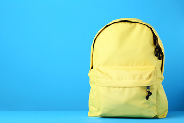 Yellow school backpack on blue background