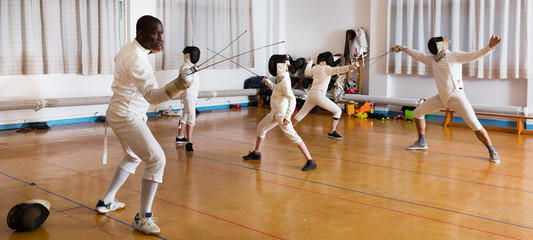 African American wearing fencing uniform practicing with foil