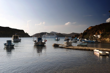Fototapeta na wymiar A view of fishing boats and a cruise ship in the beach in the island of Patmos in summer time