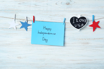 Paper stars and inscription Happy Independence Day on wooden background