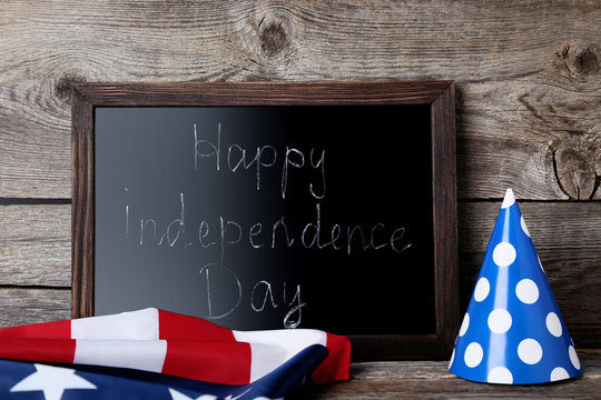 American flag and wooden frame with inscription Happy Independence Day
