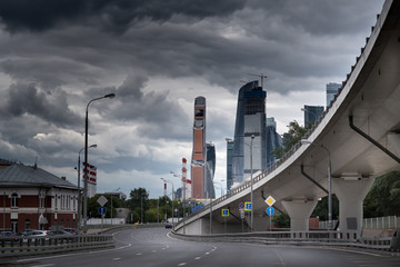 complicated highway intersection with modern city skyline at cloudy day in moscow russia, road transportation infrastructure.