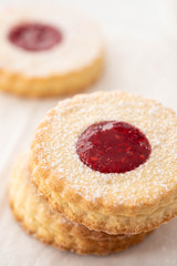 Traditional Christmas Linzer cookies with sweet jam on plate, closeup, copy space.