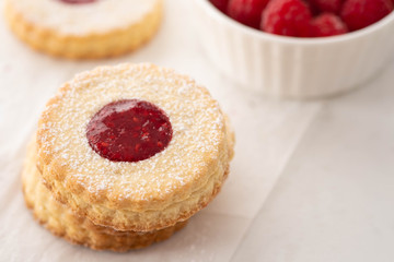 Traditional Christmas Linzer cookies with sweet jam on plate, closeup, copy space.
