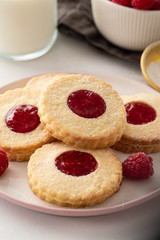 Traditional Christmas Linzer cookies with sweet jam on plate, closeup, copy space.