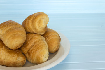 croissants in a white plate on a blue background